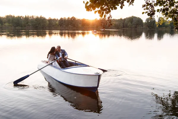 Belo jovem casal de barco no lago ao pôr-do-sol. Duas pessoas. mulher e homem — Fotografia de Stock