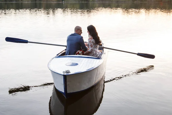 Beautiful young couple boating on the lake at sunset. two people. woman and man — Stock Photo, Image