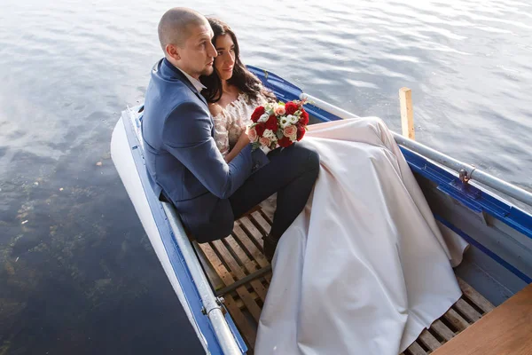 loving wedding couple in a boat on the lake