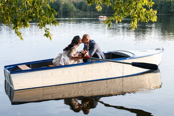 Amante pareja de boda en un barco en el lago — Foto de Stock