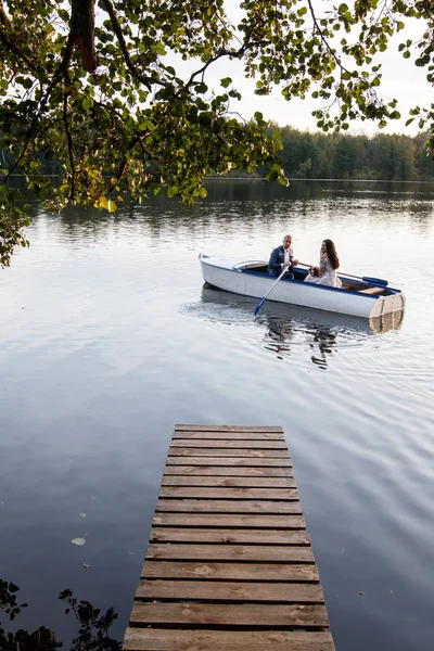 Loving wedding couple in a boat on the lake — Stock Photo, Image