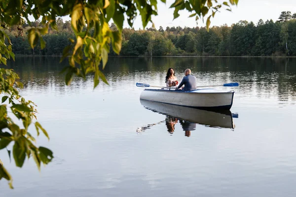 Loving wedding couple in a boat on the lake — Stock Photo, Image