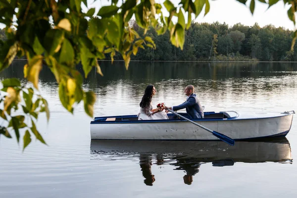 Amante pareja de boda en un barco en el lago — Foto de Stock