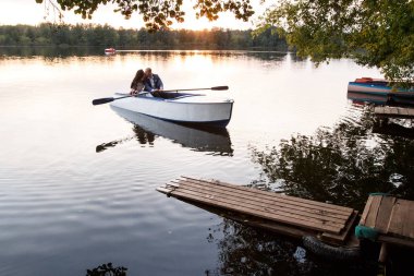 Genç Düğün çifti düğün grup bir tekne yüzer, ön planda boat.sit poz