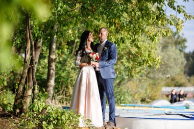 Yeni evli bir çift portreleri. Düğün çifti sipariş arka plan üzerinde duruyor. Mutlu aşıklar.