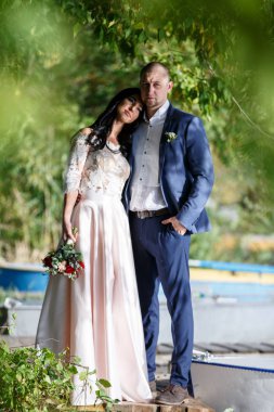 Yeni evli bir çift portreleri. Düğün çifti sipariş arka plan üzerinde duruyor. Mutlu aşıklar.