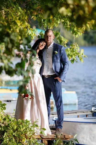 Retratos de una pareja recién casada. La pareja de boda está de pie en el fondo de la orden. Los amantes son felices. . — Foto de Stock