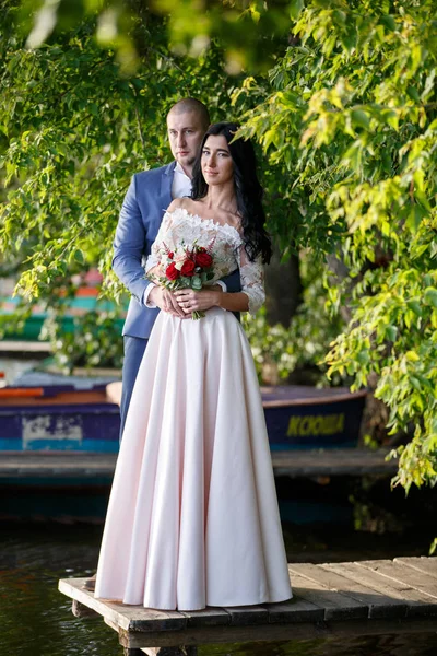 Retratos de una pareja recién casada. La pareja de boda está de pie en el fondo de la orden. Los amantes son felices. . — Foto de Stock