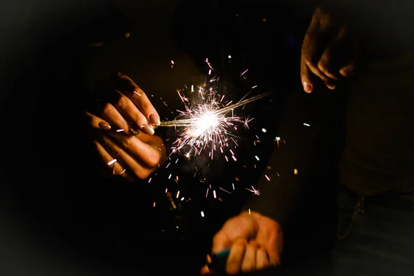 Genç bir çift Bengal ışıklar elinde ile gülüyor. Geceleri sokakta