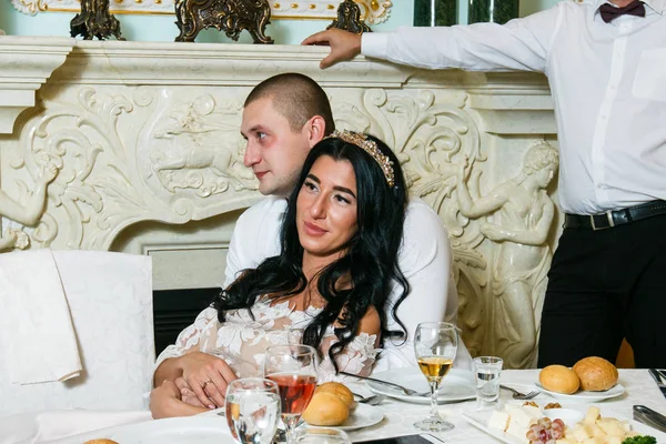 Novio y novia en un hermoso restaurante, una sala con columnas.Happy novia y novio en el interior vintage de resrourant — Foto de Stock