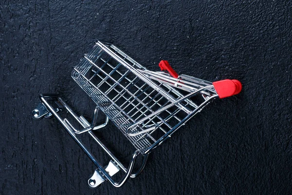 Um carrinho de compras minúsculo no fundo isolado — Fotografia de Stock