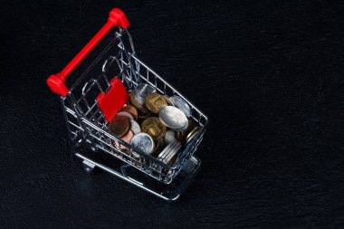 Paralar siyah koyu arka plan üzerine izole arabası minyatür.