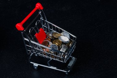 Paralar siyah koyu arka plan üzerine izole arabası minyatür.
