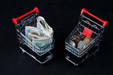 jeton cinsinden banknot yığını üzerinde mini alışveriş sepeti
