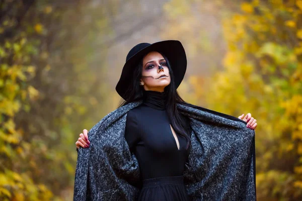 Schöne Mädchen mit schwarzen Haaren posiert draußen im Kostüm für Halloween — Stockfoto