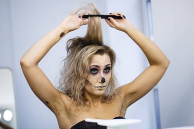 parlak kalıcı makyaj ile genç bir kız kendini aynaya bakıyorum bir headdress yapar