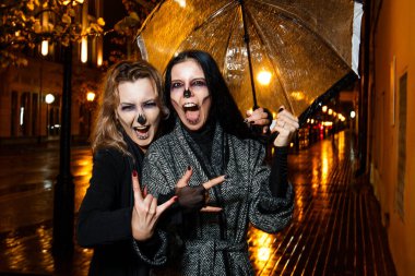 İki genç ve güzel kadın Cadılar Bayramı akşam sokakta yürüme makyaj