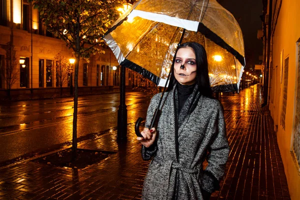 Heiliges Make-up. Mädchen mit Regenschirm abends auf der Straße — Stockfoto