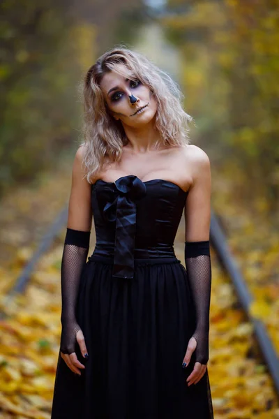 Una mujer está usando maquillaje esquelético en su cara para una celebración de Halloween o disfraz idea.outdoor. Belleza del infierno, retrato femenino espeluznante , — Foto de Stock