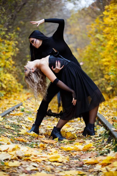 Dos brujas de la vendimia se reunieron para la víspera del sabbat de Halloween.Otoño. día, ferrocarriles . — Foto de Stock