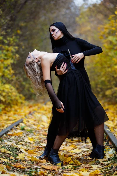 Deux sorcières millésimées se sont rassemblées pour la veille du sabbat de Halloween.autumn. jour, rails ferroviaires . — Photo