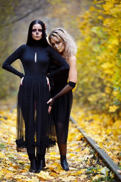 Két Évjárat boszorkányok Halloween.autumn István előestéjén gyűlt össze. nap, vasúti sínek. — Stock Fotó