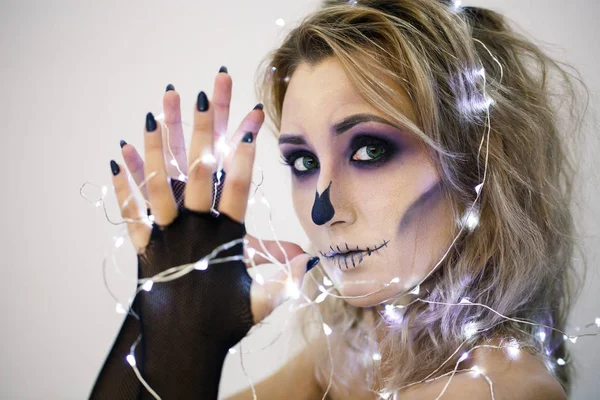Attractive woman with sugar skull make-up  dolding burning garlands in hands — Stock Photo, Image