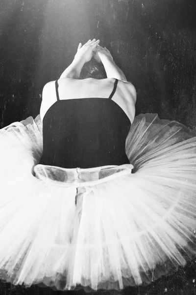 Жінка балерина в білій упаковці позує на чорному темному фоні — стокове фото