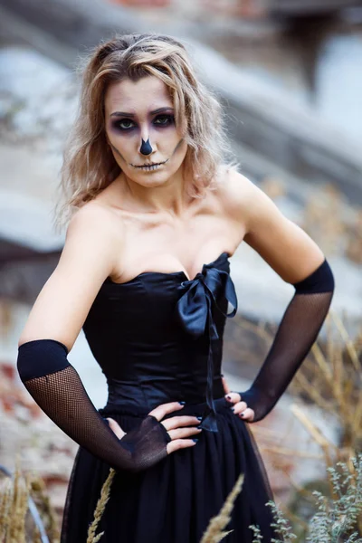 Blonde žena v sexy černých šatech zničil dům uvažuje o devastaci. Halloween make-upu — Stock fotografie