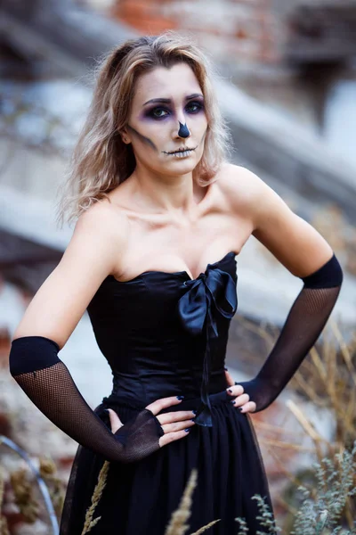Blond kobieta sexy czarna sukienka zniszczony dom kontemplując dewastacji. Halloween makijaż — Zdjęcie stockowe