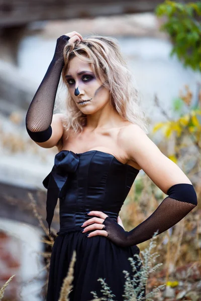 Mujer rubia en un vestido negro sexy destruyó la casa contemplando la devastación. Halloween conforman — Foto de Stock