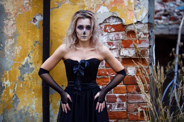 Blonde Woman in a sexy black dress destroyed house contemplating devastation. halloween make up — Stock Photo, Image