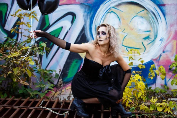 Blonde Woman in a sexy black dress destroyed house contemplating devastation. halloween make up — Stock Photo, Image