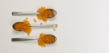 Beyaz arka planda izole edilmiş kaşıkta havyar. Lüks mutfak.