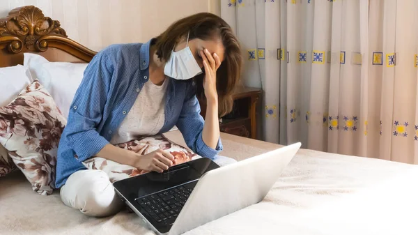 İnternette çalıştıktan sonra maske takan genç bir kadın yatakta oturmaktan yoruldu.