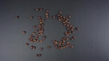 Bir fincan sade kahve ile stok video izleme eli kahve çekirdekleri ve siyah arka planda koydu. Sütsüz kahve.