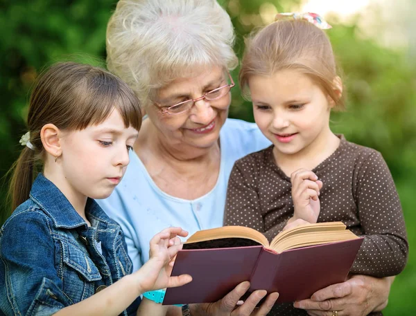 Concepto de educación, abuela leyendo un libro para nietos — Foto de Stock