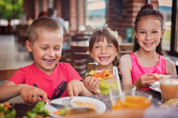 ピザを食べて 一緒に楽しんで幸せな子供たち ストック画像