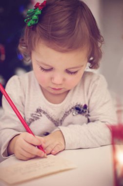 Noel Baba 'ya mektup yazan şirin bir bebeğin Noel portresi.