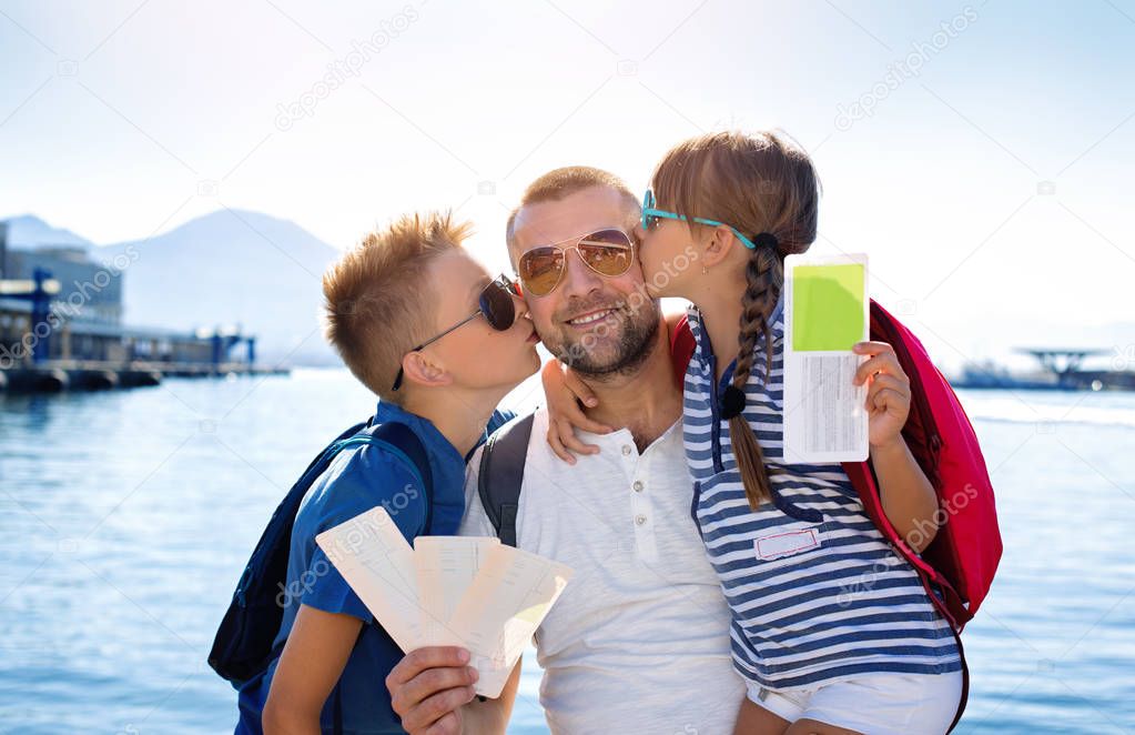 Summer holidays.Father with children are waiting summer sea vacation