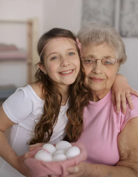 イースターのコンセプト 孫娘と祖母は自宅でイースターエッグを保持しています — ストック写真