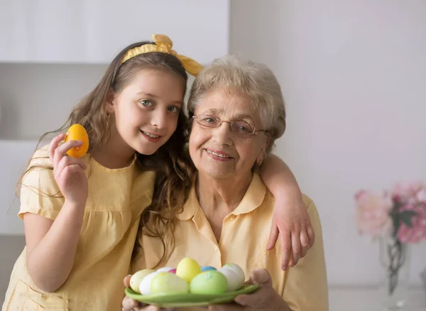 イースターのコンセプト 孫娘と祖母は自宅でイースターエッグを保持しています — ストック写真