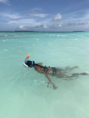 Genç bir kadın denizde yüzüyor. 