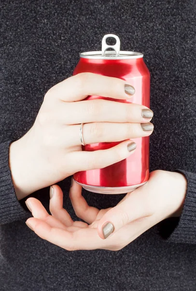 Female holding an open can of soda