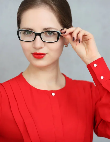 Mode zakenvrouw met een rood shirt en glazen portret, zonnebril met in zijn hand — Stockfoto