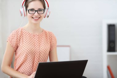 Öğrenci ile bir dizüstü bilgisayar müzik ve öğrenme onun kucağına oturur. Gülümseyen ve kameraya bakıyor.