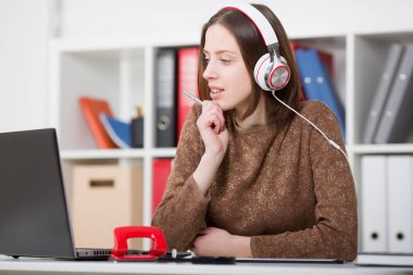 Güzel kız öğrencinin öğrenme ve müzik kulaklık ile. Elini ve laptop monitör seyir kolu tutun