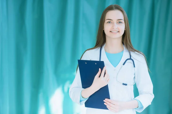 Γυναίκα γιατρός με ένα φάκελο για τις σημειώσεις στα χέρια — Φωτογραφία Αρχείου