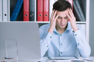 Stresli bir durum ofiste oturan işadamı. Kafanı ve sakinleştirmeye çalışırken ellerini tutun