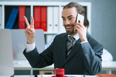 Telefonda iyi haber alma iş adamı. Mutlu ve bir zafer kutluyor.